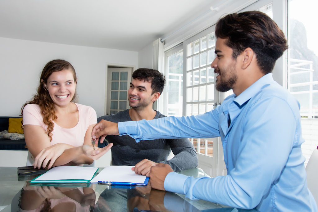 Apartment leasing agent shaking hands with renters